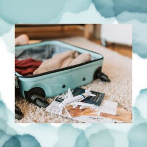 Open turquoise suitcase with clothes spilling out, beside travel documents and a toy airplane on a carpeted floor, ready for travel planning.